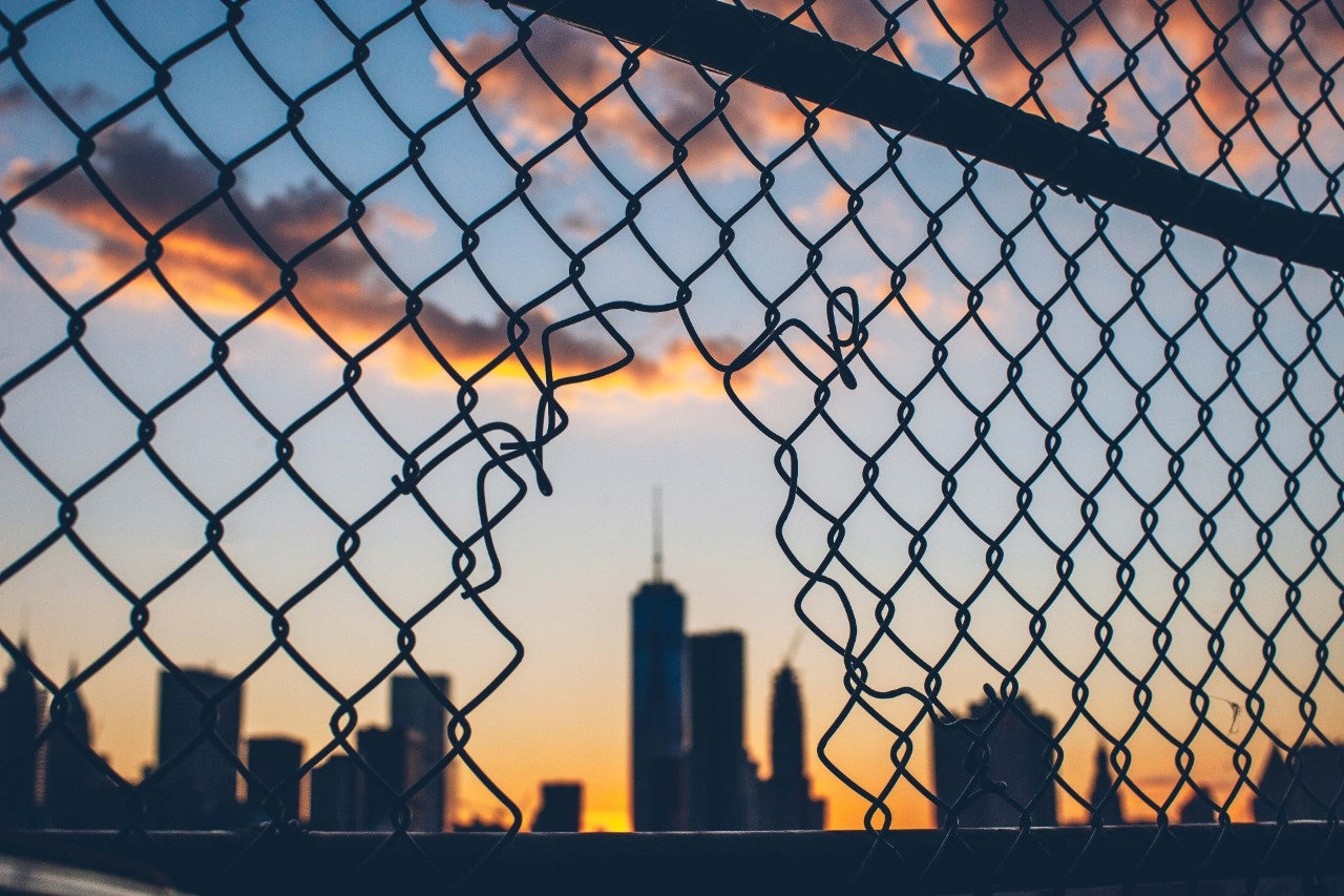 ws_cut_wire_fence_against_city_sunset