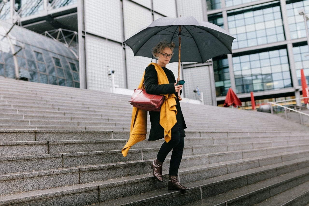 ws_mature_woman_on_steps_on_phone_with_umbrella